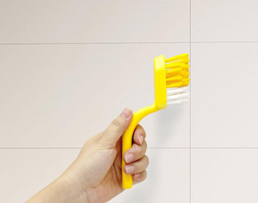 Cleaning tile grout with brush