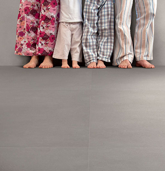 Waist down photo of a family standing barefoot on tiles