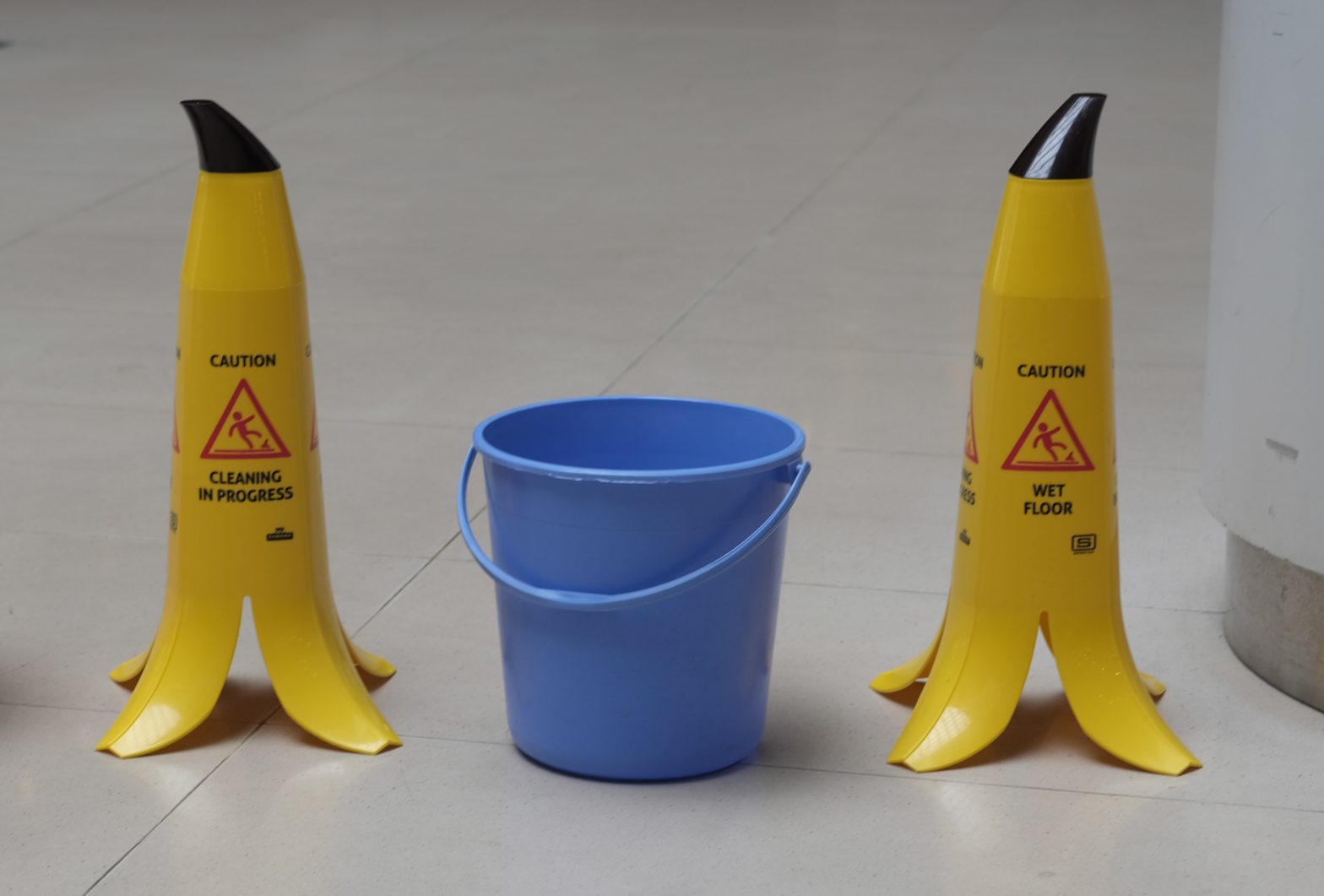 Slippery floor signs next to a bucket