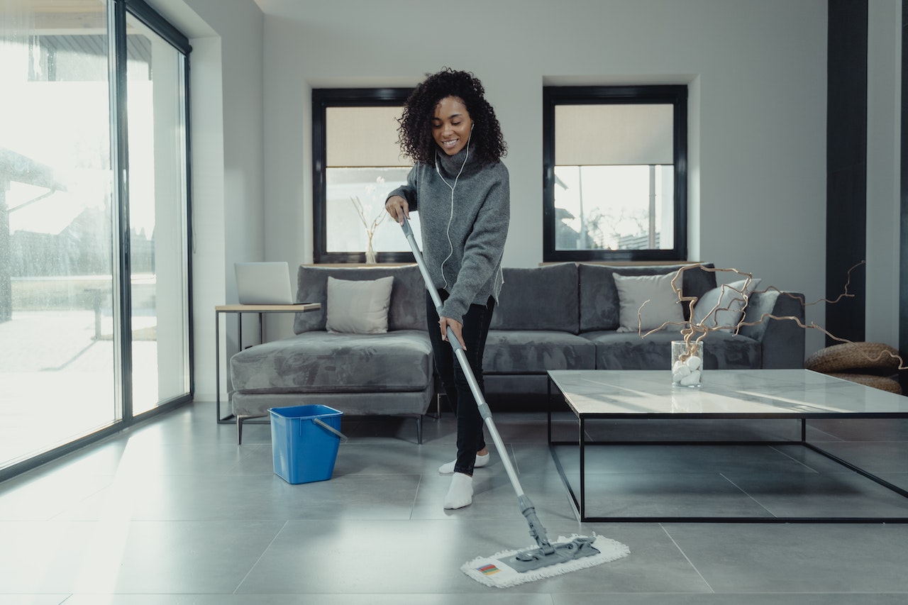 woman cleans living room tiles